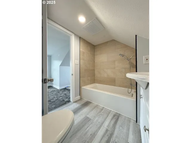 a view of a hallway with a room and a bathroom