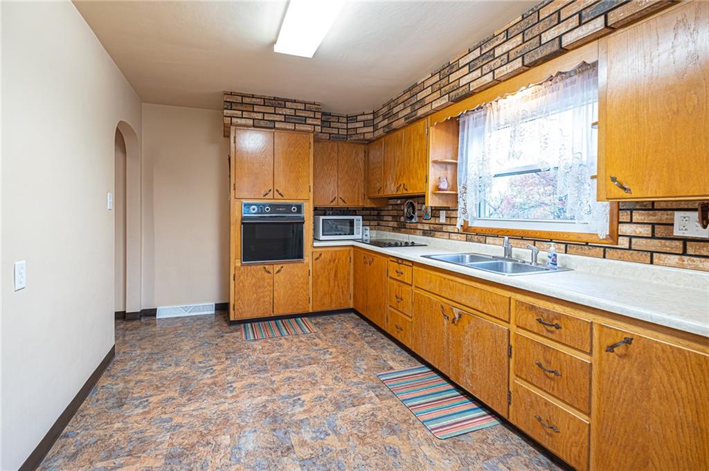New laminate floor, rustic kitchen cabinets, electric wall oven and cooktop 