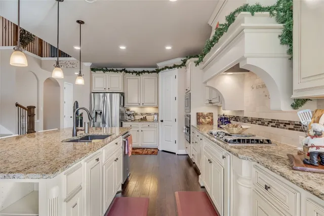 a large white kitchen with lots of counter space a sink and appliances