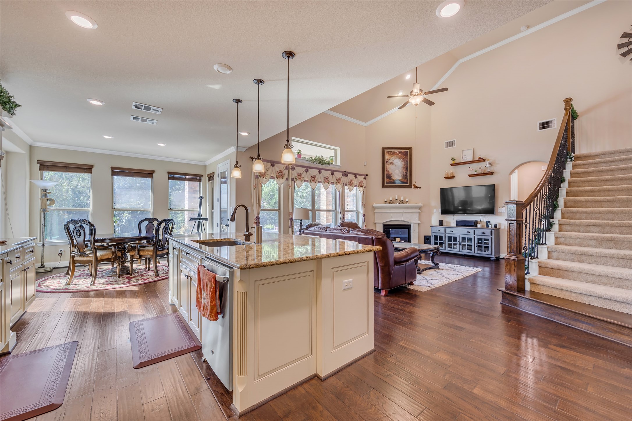 103 County Road 180, Unit 23 Leander, TX 78641 - Photo 13 of 40 Kitchen with ornamental molding, a glass covered fireplace, light stone countertops, pendant lighting, and dark wood-style flooring