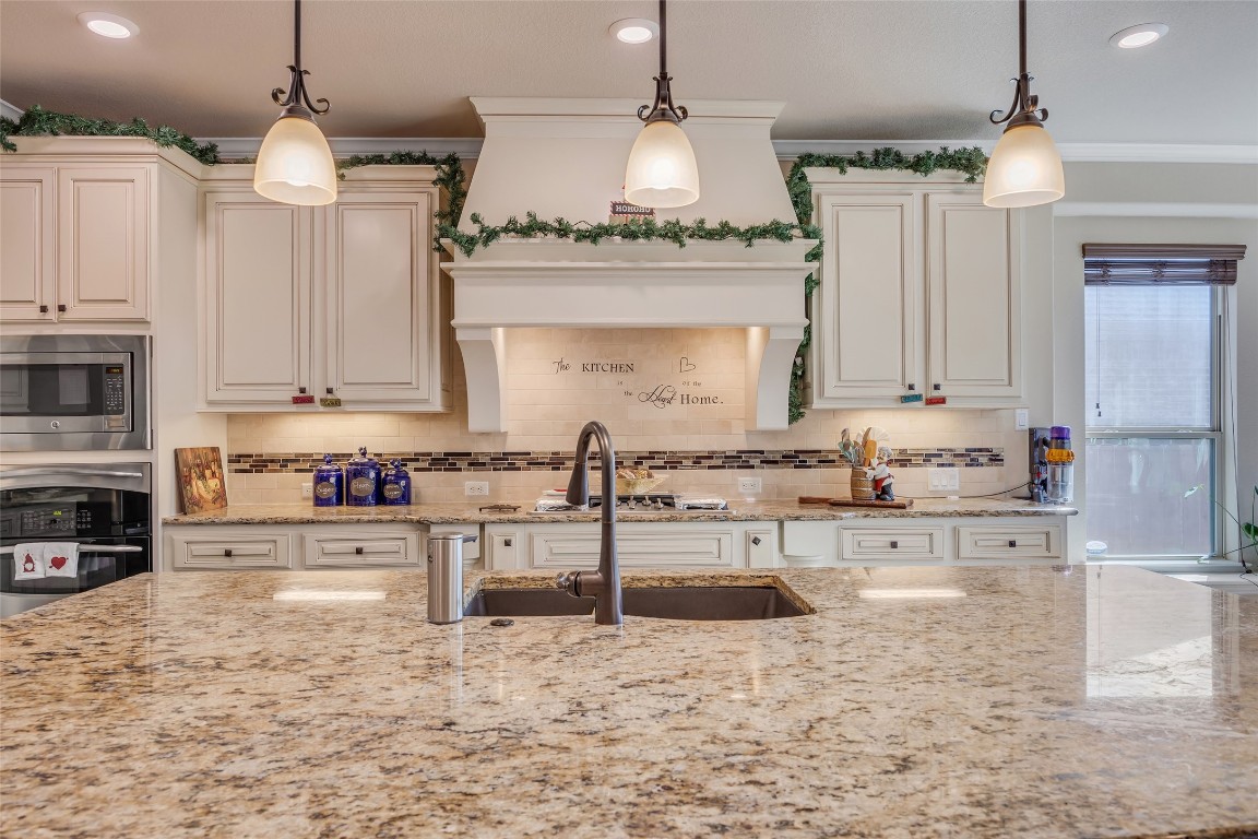 103 County Road 180, Unit 23 Leander, TX 78641 - Photo 13 of 40 a large kitchen with granite countertop a sink and white cabinets