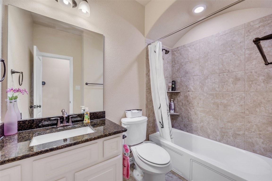103 County Road 180, Unit 23 Leander, TX 78641 - Photo 27 of 40 a bathroom with a granite countertop toilet sink and shower