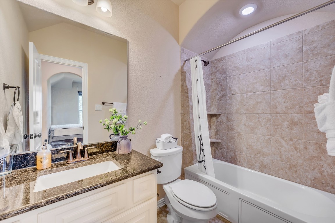 103 County Road 180, Unit 23 Leander, TX 78641 - Photo 33 of 40 a bathroom with a granite countertop sink toilet and shower