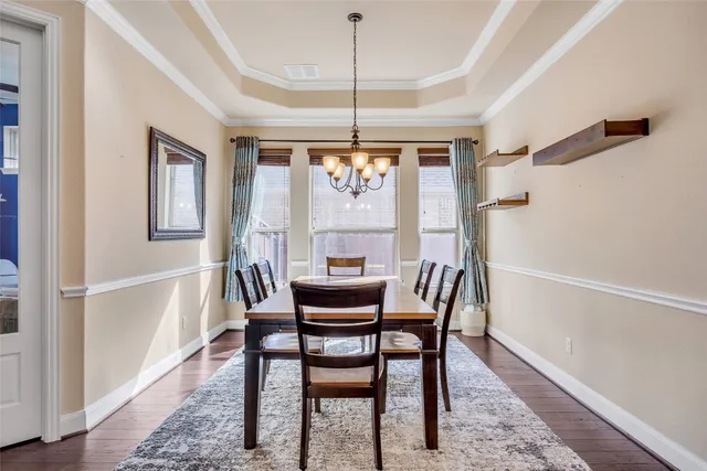 a dining room with furniture a chandelier and wooden floor
