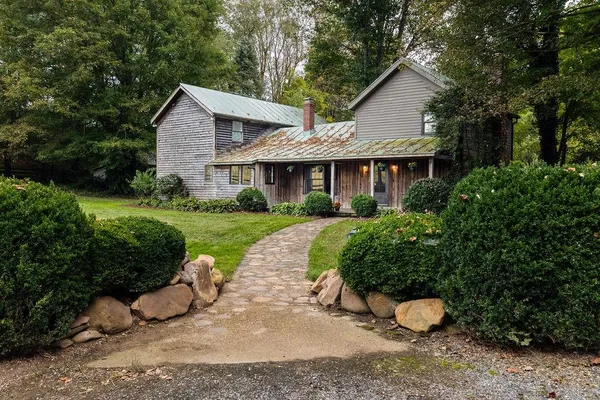 a view of a house with a yard and potted plants