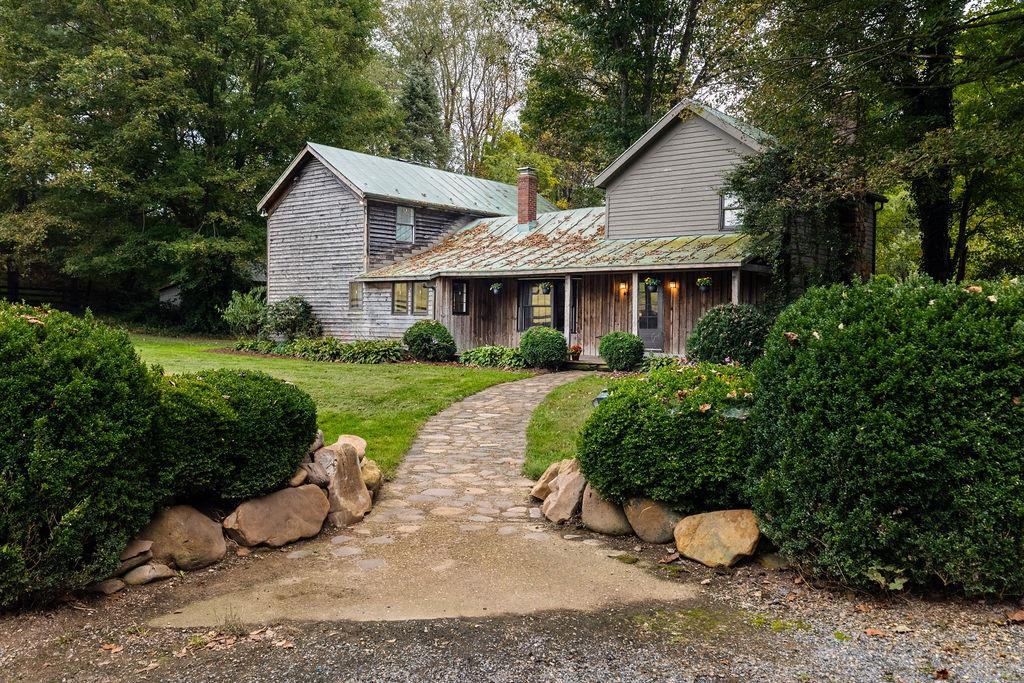 a view of a house with a yard and potted plants