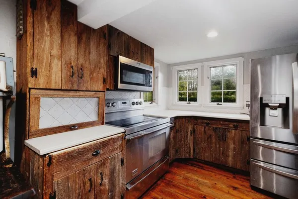 a kitchen with kitchen island granite countertop a sink cabinets and wooden floor