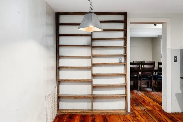 a view of a room with wooden floor and entryway