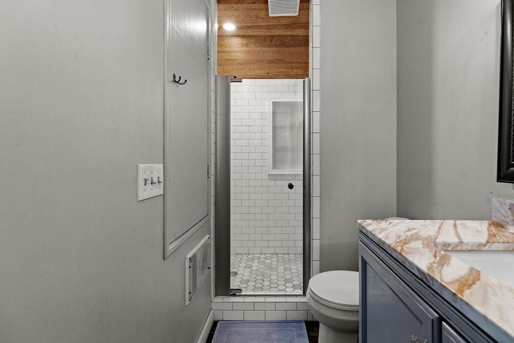 8787 Thorny Branch Road Bridgewater, VA 22812 - Photo 40 of 46 a bathroom with a granite countertop toilet a sink and a shower