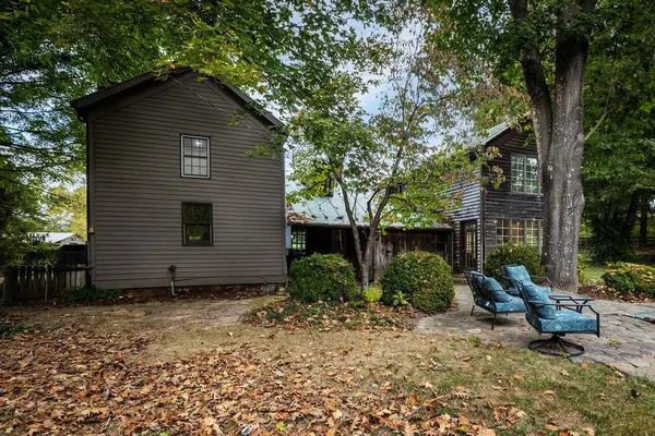 a view of a house with a yard and large trees