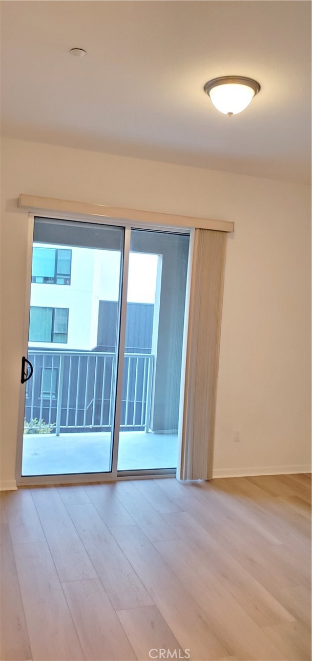 21 Gramercy, Unit 307 Irvine, CA 92612 - Photo 22 of 65 an empty room with wooden floor and windows