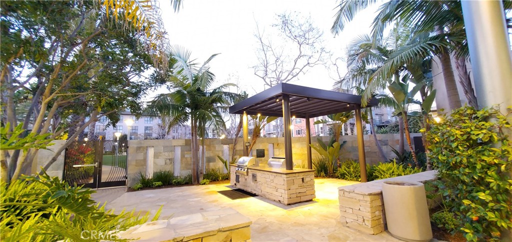 21 Gramercy, Unit 307 Irvine, CA 92612 - Photo 54 of 65 a view of a patio with table and chairs under an umbrella with potted plants