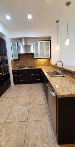 a large kitchen with granite countertop a stove and a refrigerator