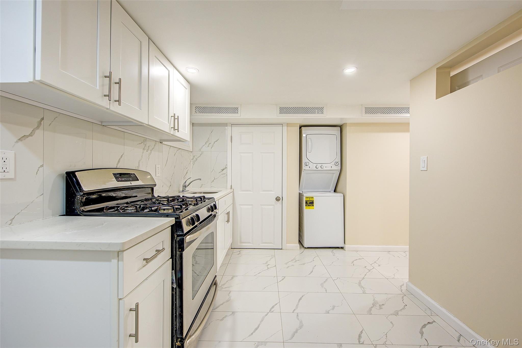 164-38 76th Road Queens, NY 11366 - Photo 28 of 44 a kitchen with a stove a refrigerator and cabinets