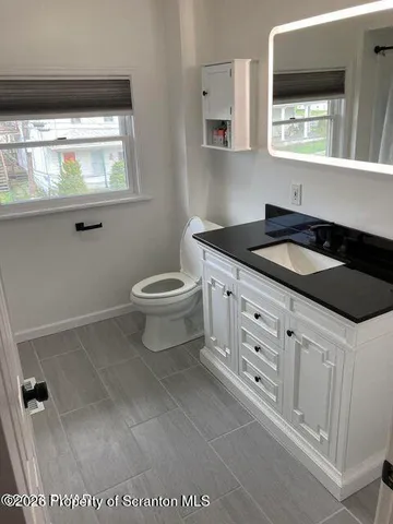 a kitchen with white cabinets and a refrigerator