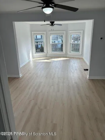 wooden floor in an empty room with a window