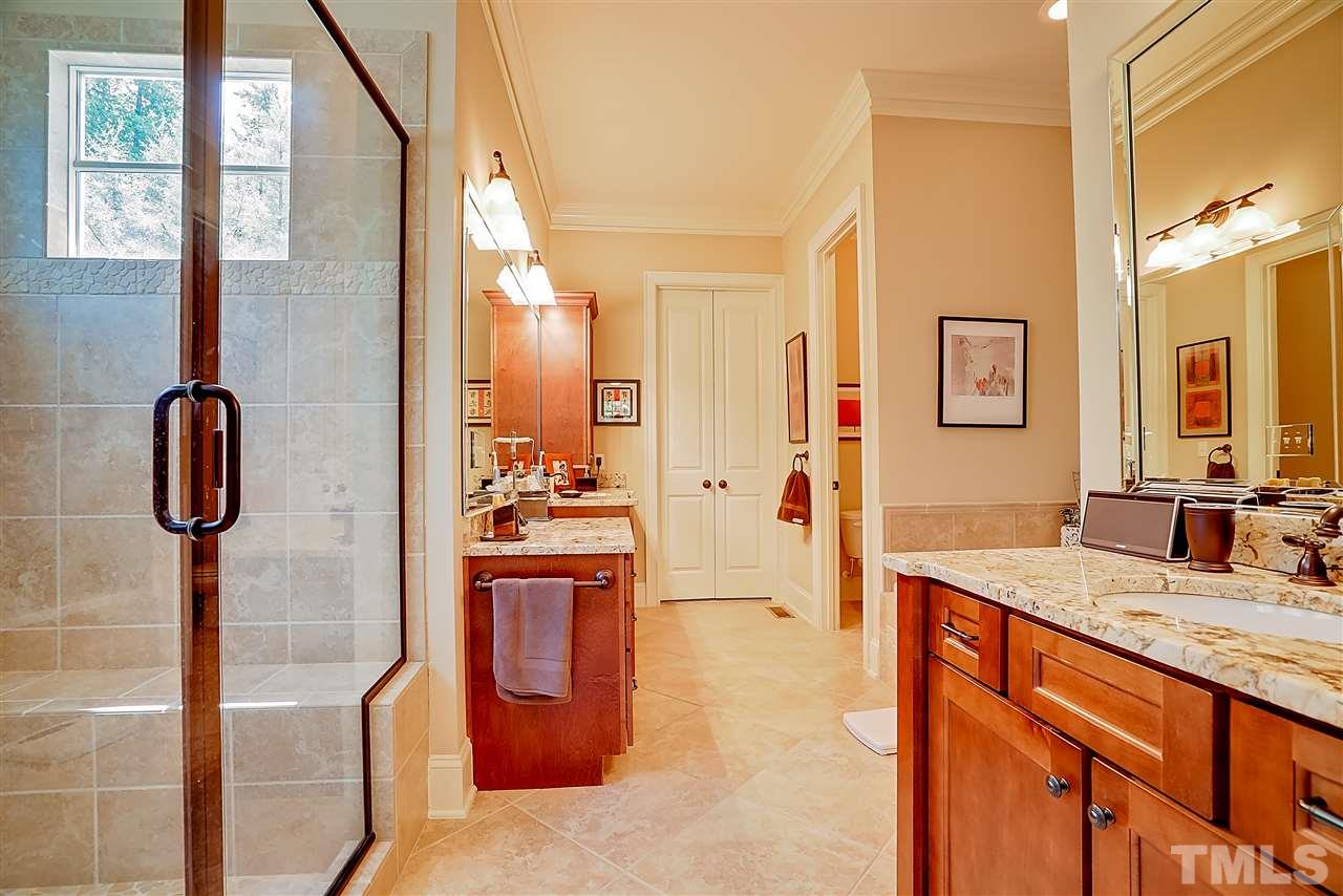 8636 Baybridge Wynd Raleigh, NC 27613 - Photo 13 of 25 a bathroom with a granite countertop sink a mirror and shower