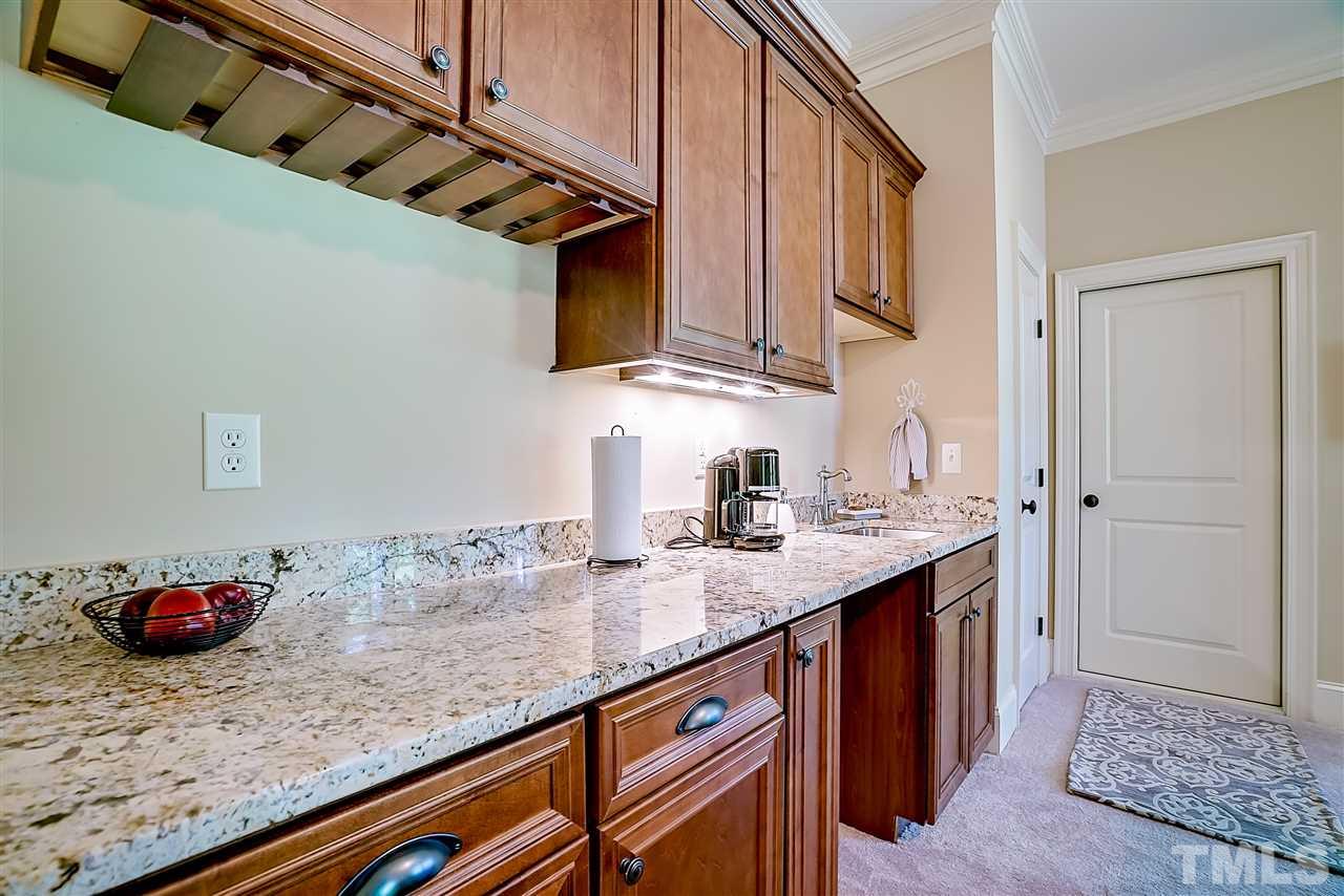 8636 Baybridge Wynd Raleigh, NC 27613 - Photo 21 of 25 a kitchen with stainless steel appliances granite countertop a sink stove and cabinets