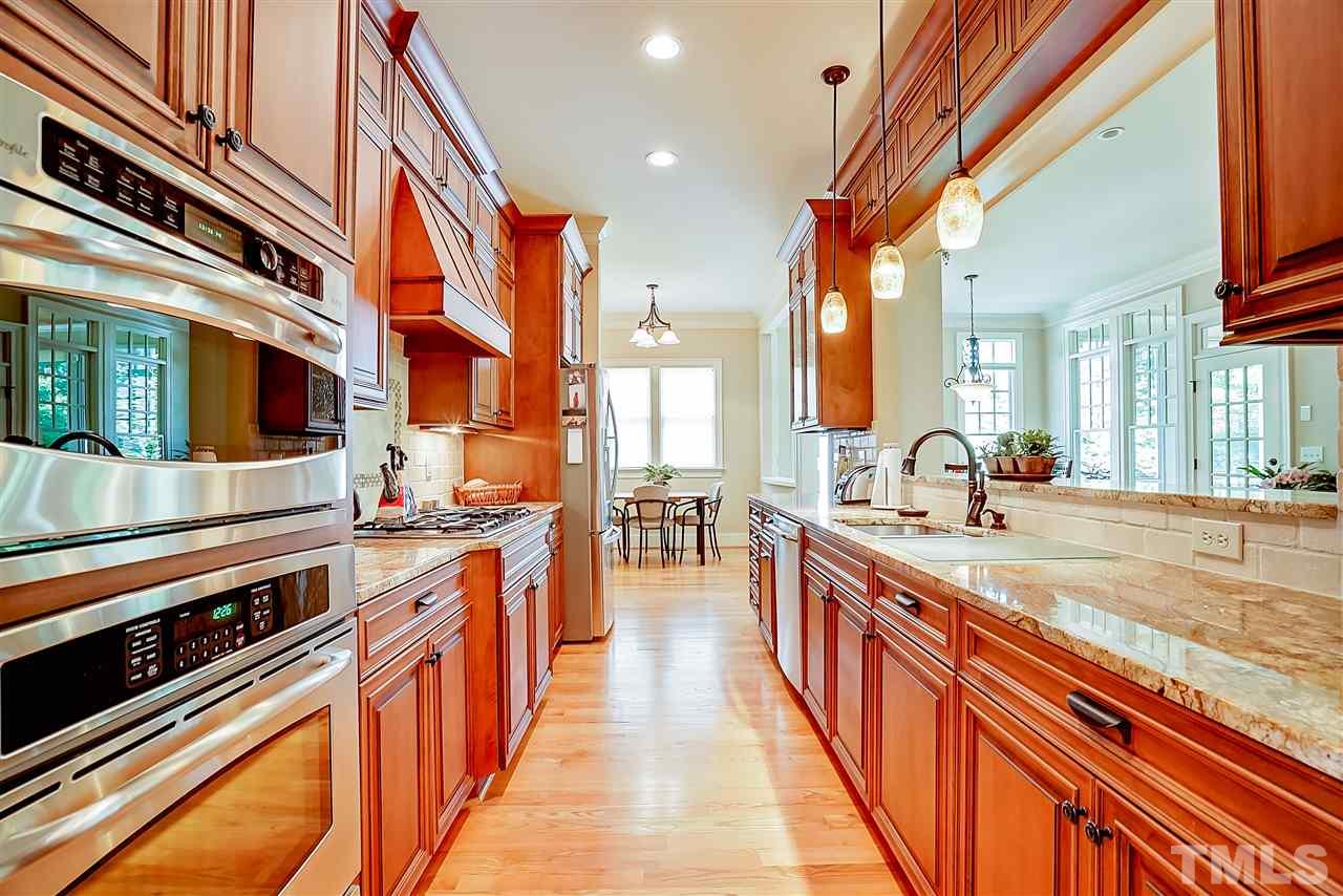 8636 Baybridge Wynd Raleigh, NC 27613 - Photo 4 of 25 a large kitchen with stainless steel appliances a stove and cabinets