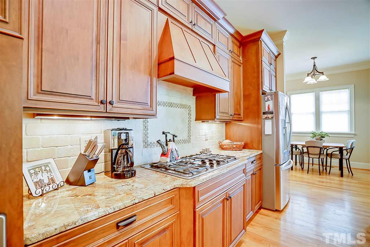 8636 Baybridge Wynd Raleigh, NC 27613 - Photo 6 of 25 a kitchen with stainless steel appliances granite countertop a sink a stove and a wooden cabinets