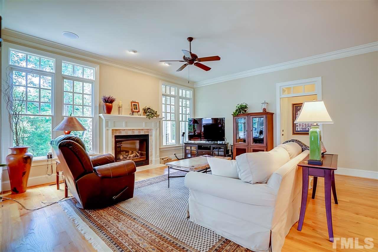 8636 Baybridge Wynd Raleigh, NC 27613 - Photo 9 of 25 a living room with furniture a fireplace and a flat screen tv