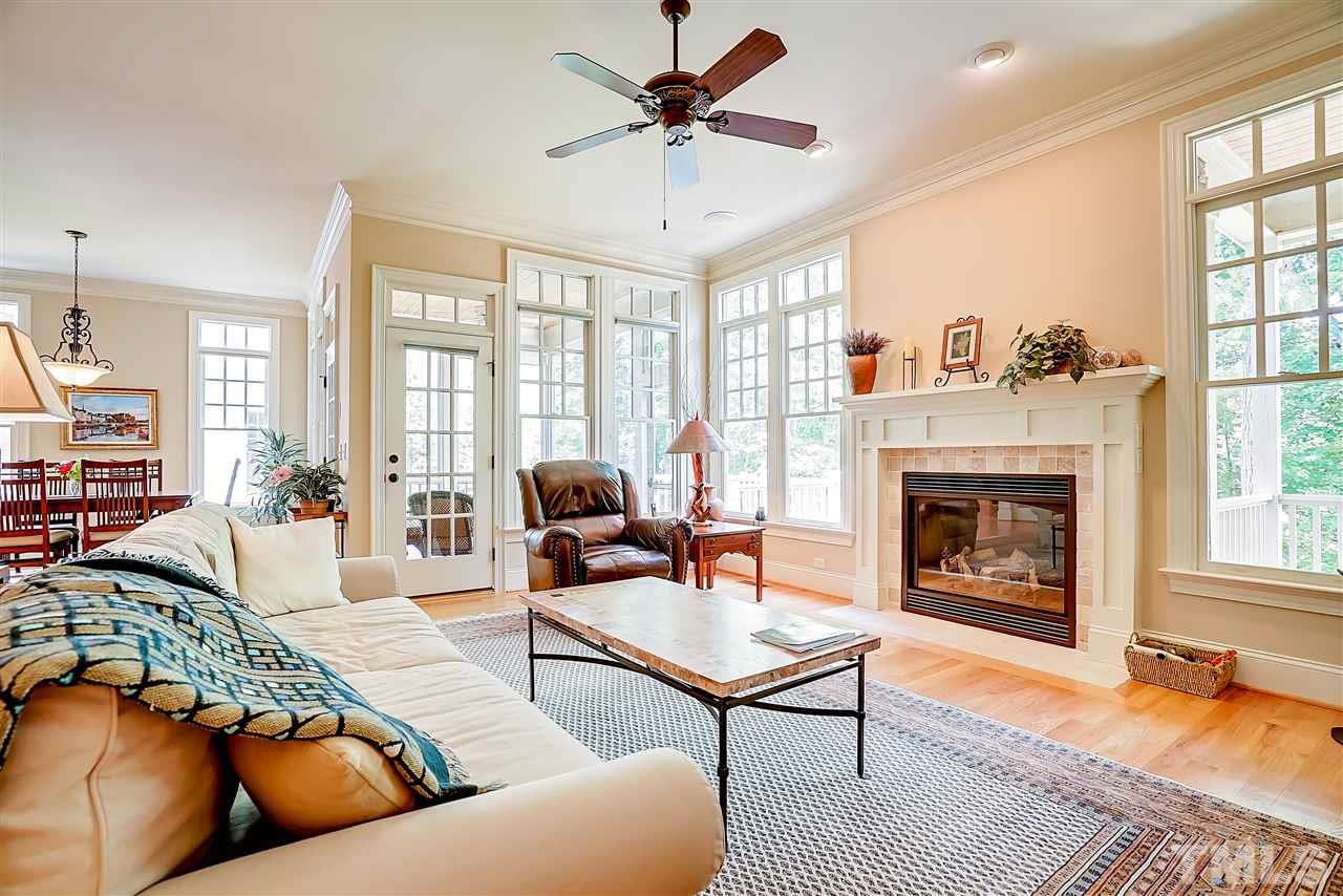 8636 Baybridge Wynd Raleigh, NC 27613 - Photo 10 of 25 a living room with furniture a fireplace and a chandelier