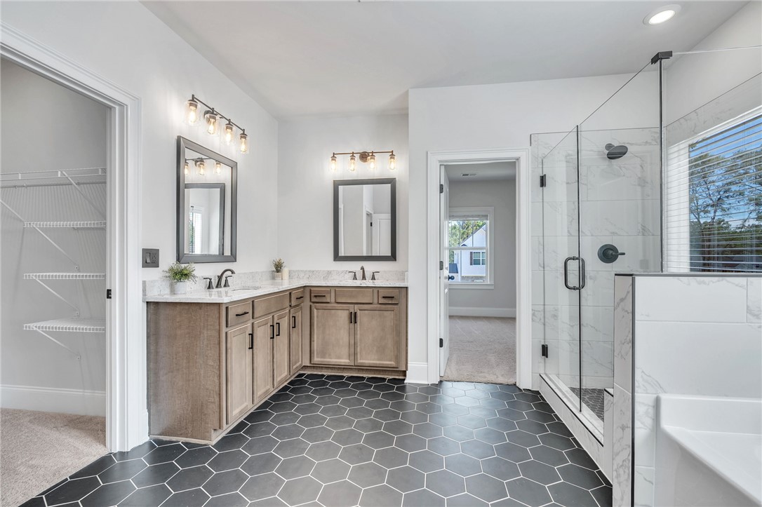 226 Holly Br Road Piedmont, SC 29673 - Photo 21 of 44 Dual vanities and a spacious glass-enclosed shower create a rejuvenating primary bathroom retreat.