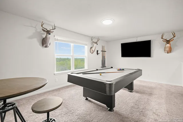 a living room with a table chairs and a flat screen tv