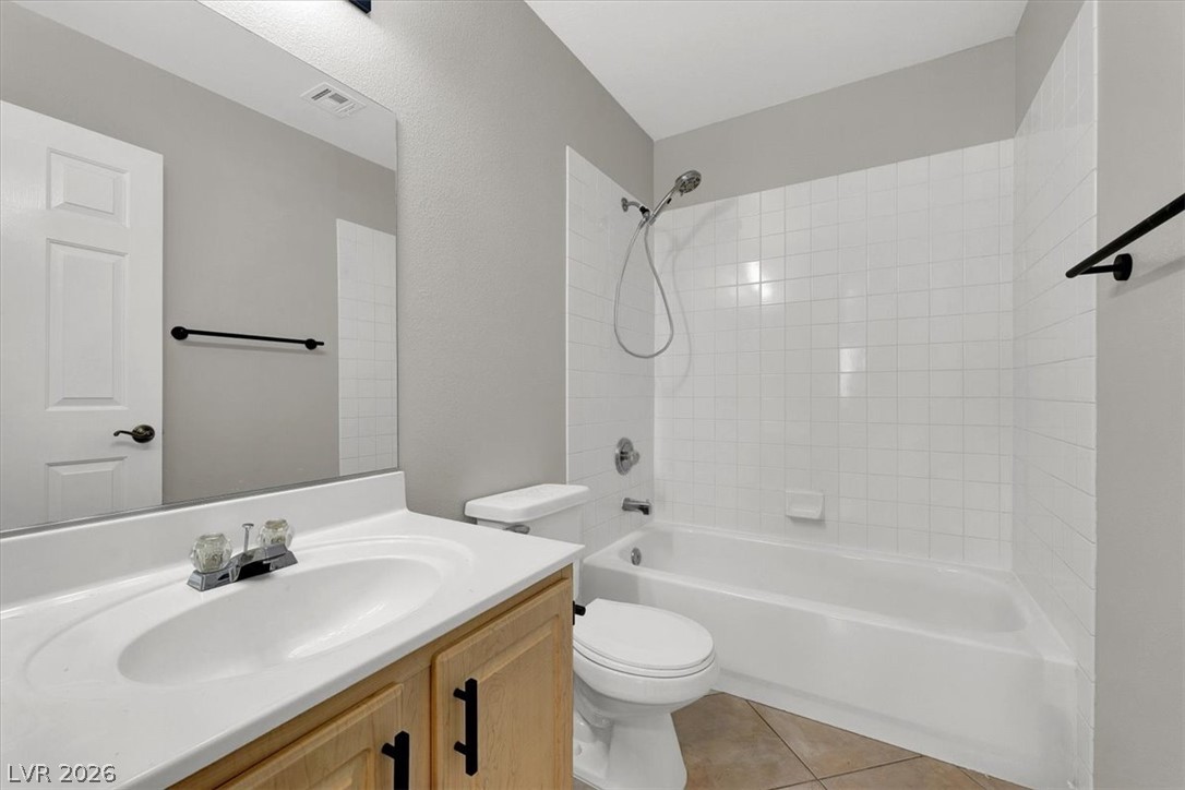 10148 Tree Bark Street Las Vegas, NV 89183 - Photo 23 of 37 A well-maintained bathroom with a sleek vanity and tiled shower.