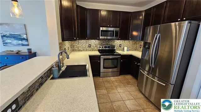 a kitchen with granite countertop a refrigerator and a sink