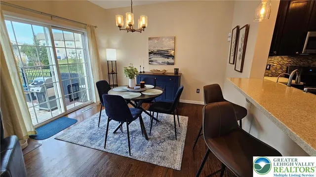 a view of a dining room with furniture a chandelier and wooden floor