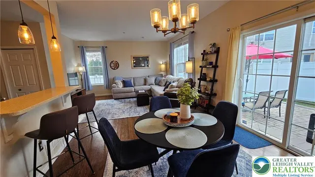 a dining room with furniture a chandelier and wooden floor