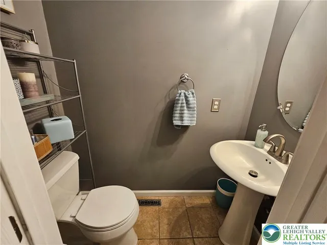a bathroom with a toilet a sink and mirror
