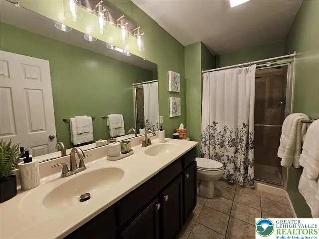 a bathroom with a double vanity sink mirror and toilet