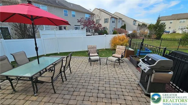 a view of a chairs and table in the back yard of the house