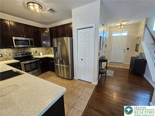 a kitchen with stainless steel appliances granite countertop a refrigerator stove top oven and sink
