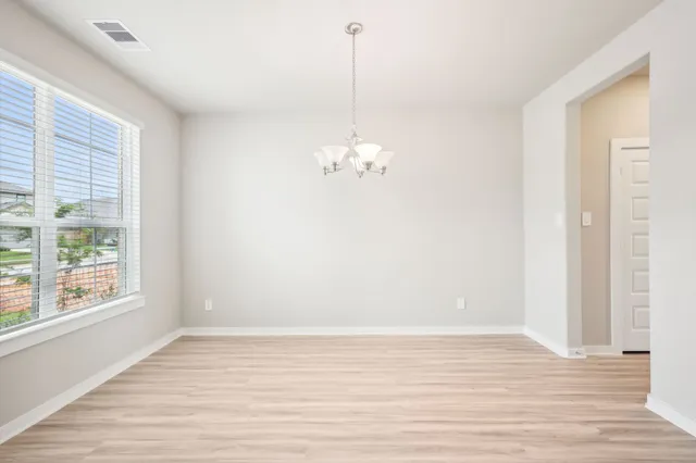 a view of a room with wooden floor and windows