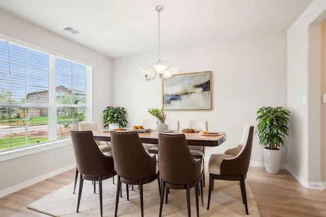 a dining room with furniture potted plants and wooden floor