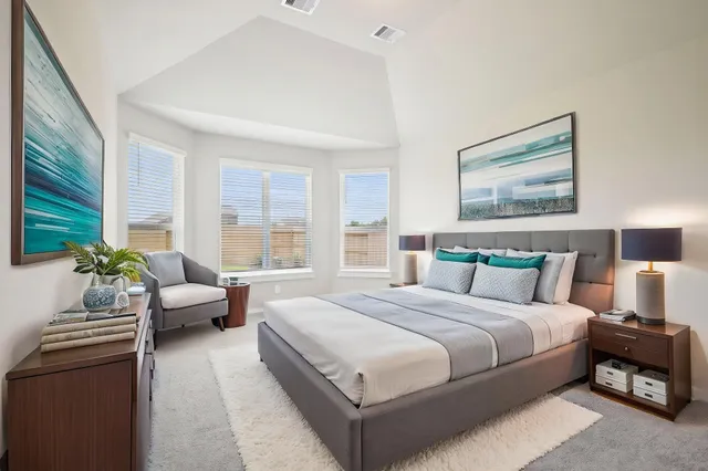 a bedroom with a bed and large windows