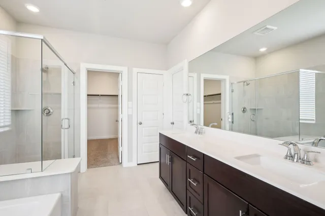 a spacious bathroom with a double vanity sink shower and a mirror