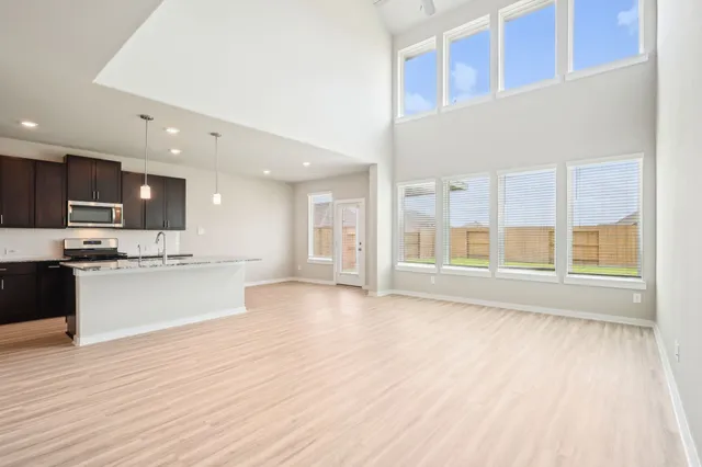 a large kitchen with stainless steel appliances kitchen island wooden cabinets and a large window
