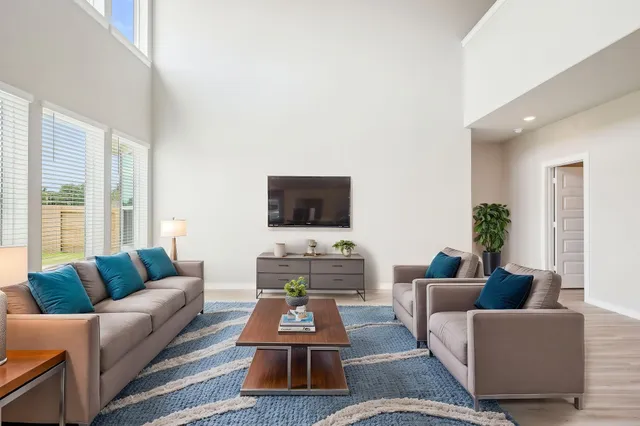a living room with furniture a rug and a flat screen tv