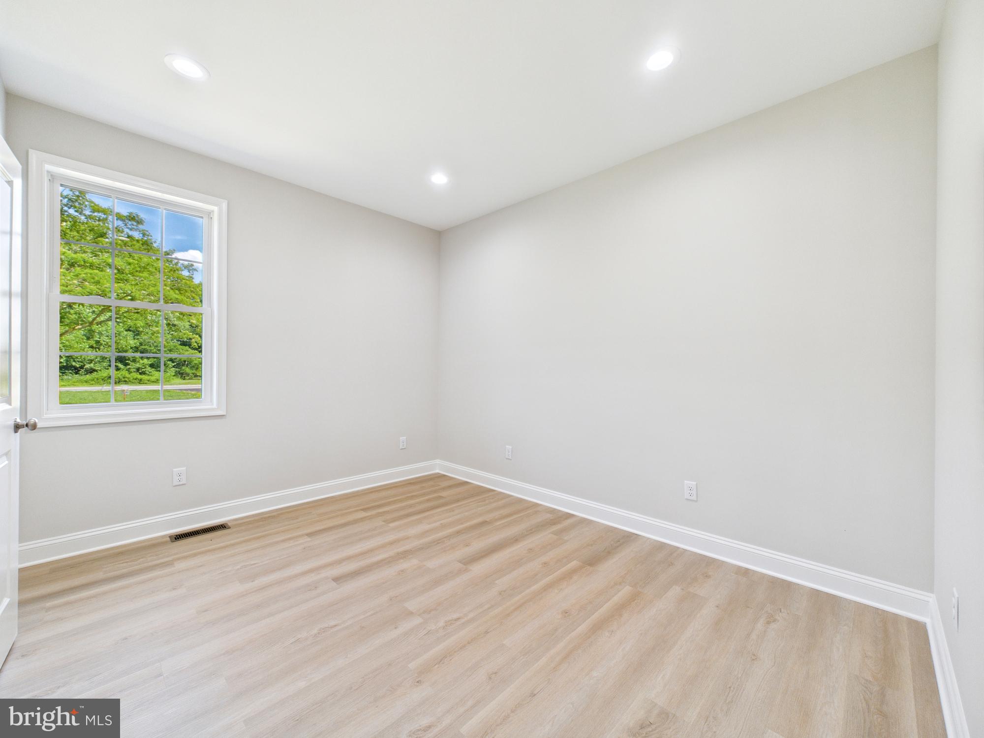 20168 Shingle Point Road Georgetown, DE 19947 - Photo 12 of 44 an empty room with wooden floor and windows