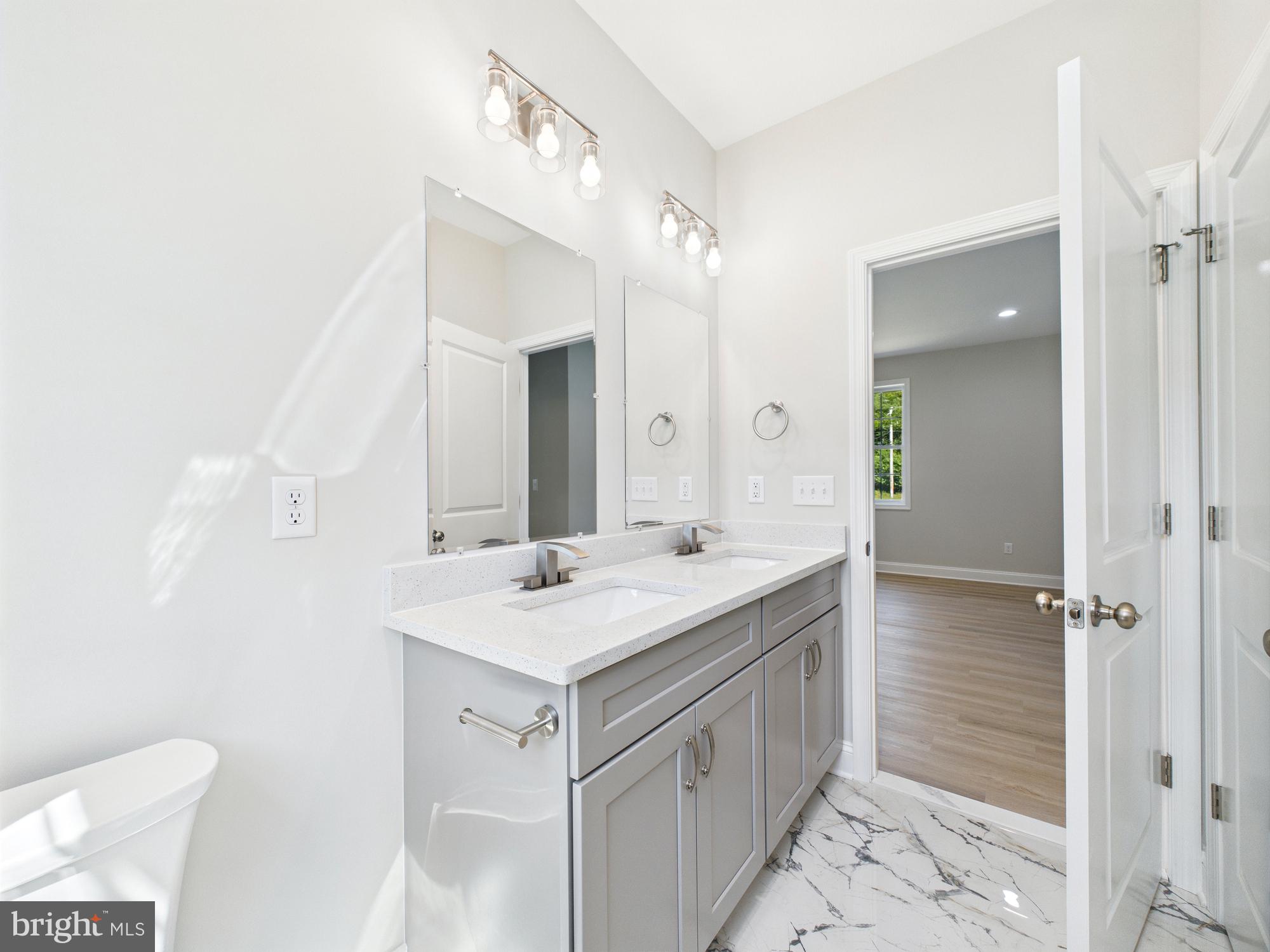 20168 Shingle Point Road Georgetown, DE 19947 - Photo 18 of 44 a bathroom with a sink a mirror and a shower