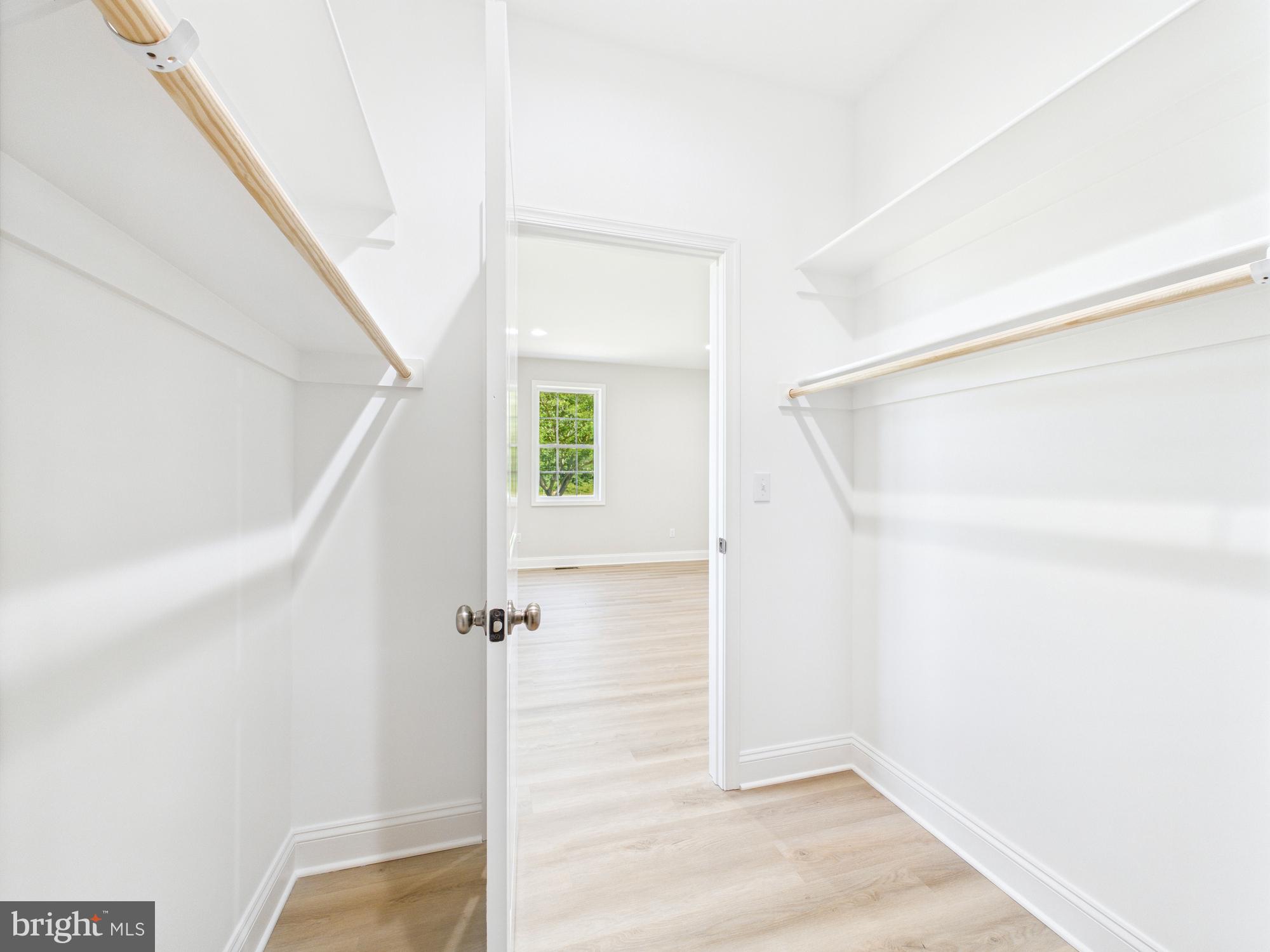 20168 Shingle Point Road Georgetown, DE 19947 - Photo 21 of 44 a view of a hallway with white walls and wooden floor