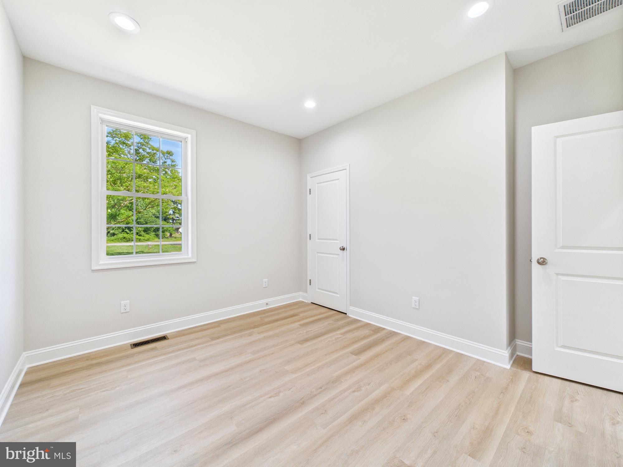 20168 Shingle Point Road Georgetown, DE 19947 - Photo 29 of 44 a view of an empty room with wooden floor and a window