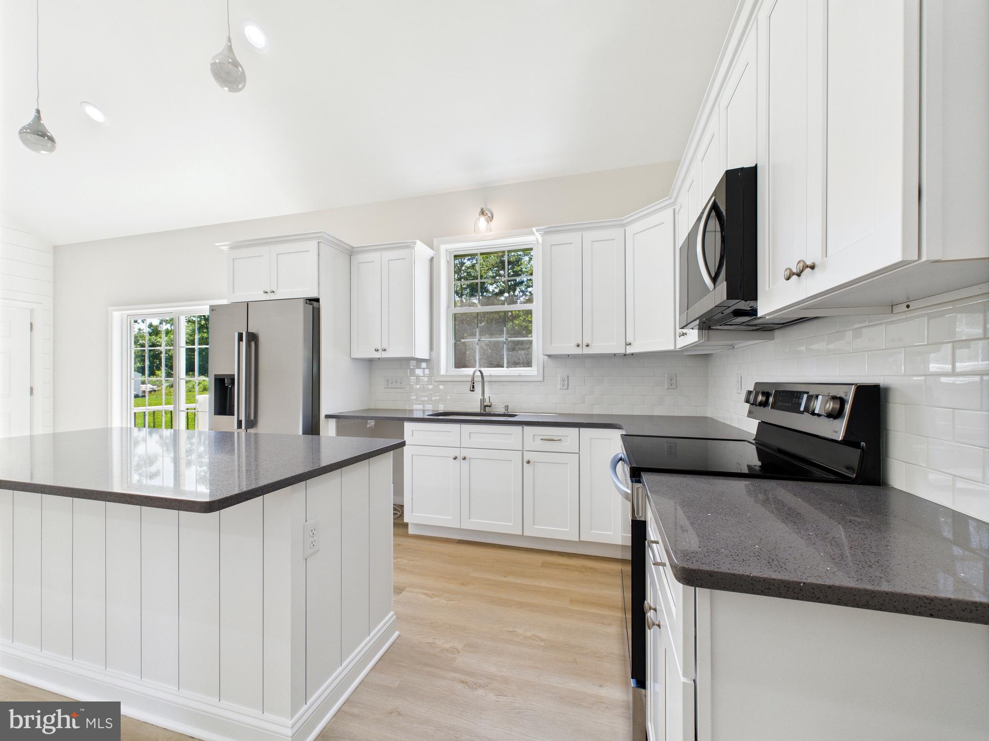 20168 Shingle Point Road Georgetown, DE 19947 - Photo 4 of 44 a kitchen with stainless steel appliances granite countertop a sink and a stove
