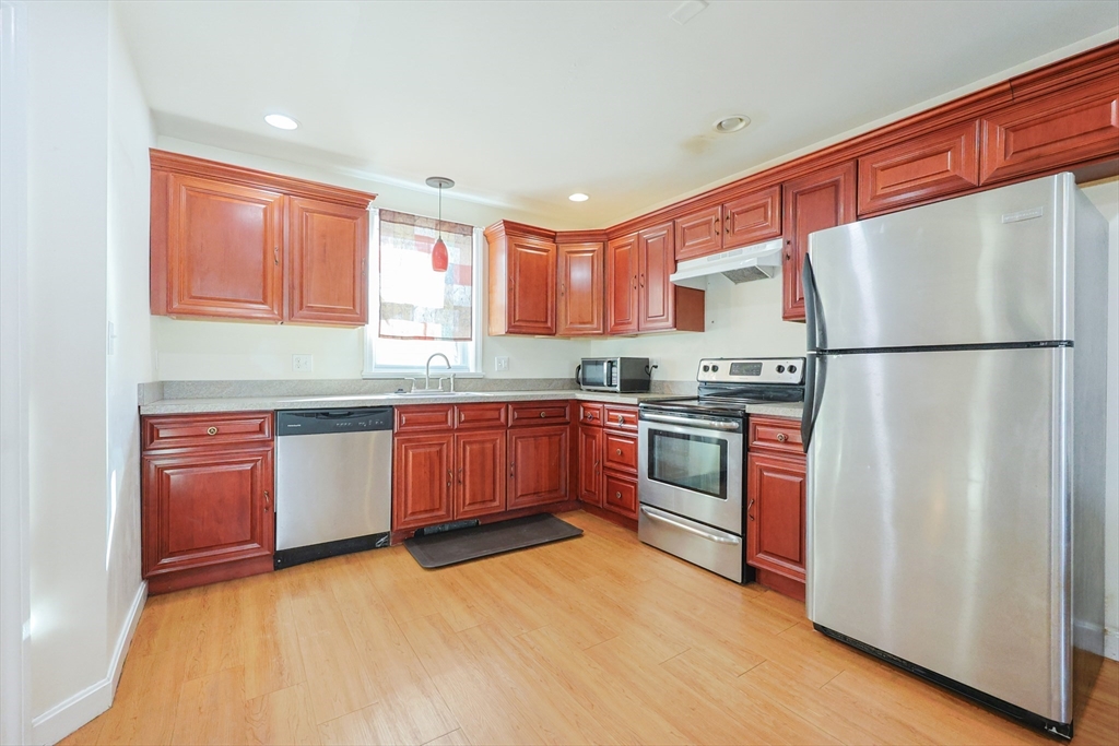 35 Miller Stile Road Quincy, MA 02169 - Photo 11 of 30 a kitchen with stainless steel appliances granite countertop a refrigerator sink and wooden cabinets