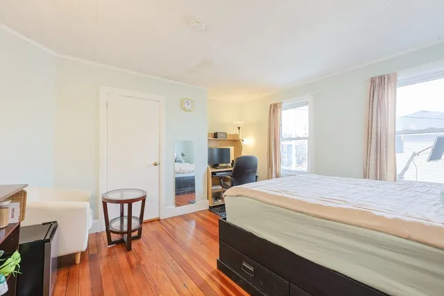 a bedroom with a bed and wooden floor