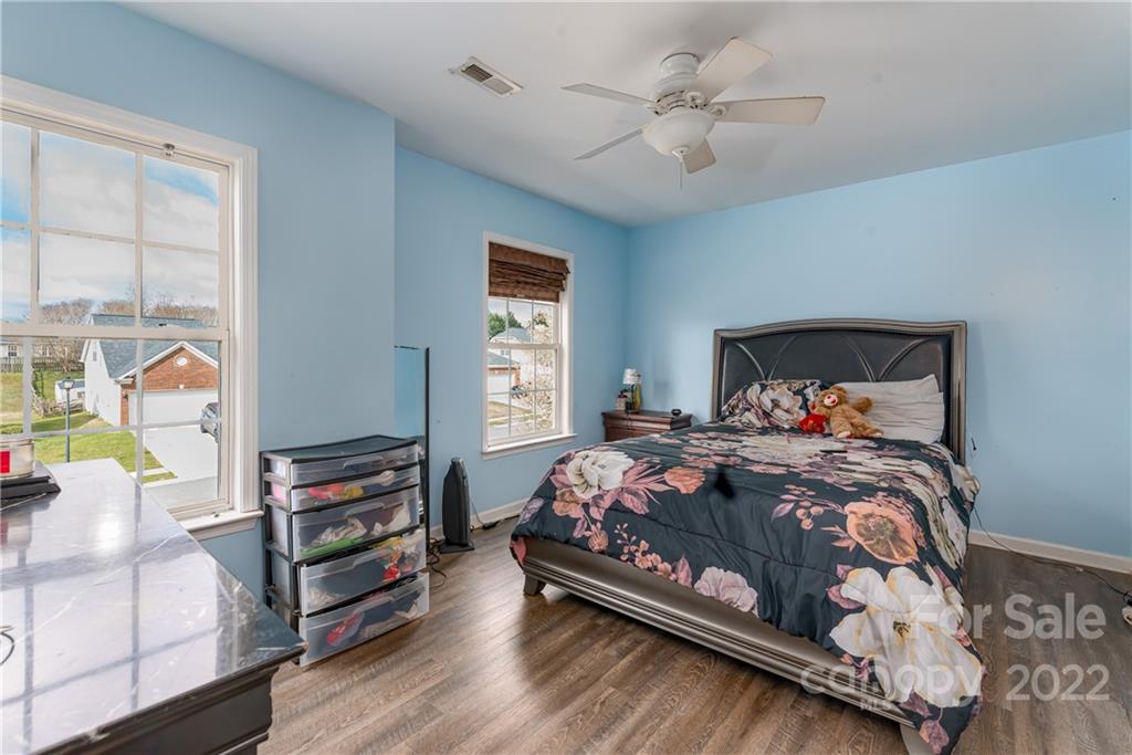 11429 Chapeclane Road Charlotte, NC 28278 - Photo 16 of 26 a bedroom with a bed and a chandelier